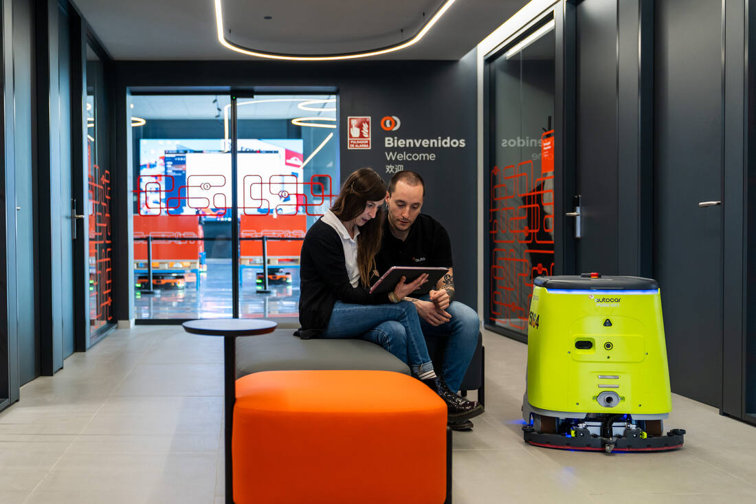 Recepción de Autocar con un robot de limpieza autónomo circulando junto a la zona de espera.